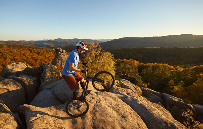 森林在日落时分 职业自行车手在试骑自行车上保持平衡后轮活动爱好
