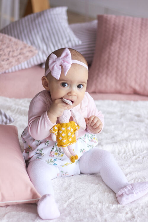 小有趣的小女婴在粉红色明亮的现代内饰母亲节概念花束休闲孩子