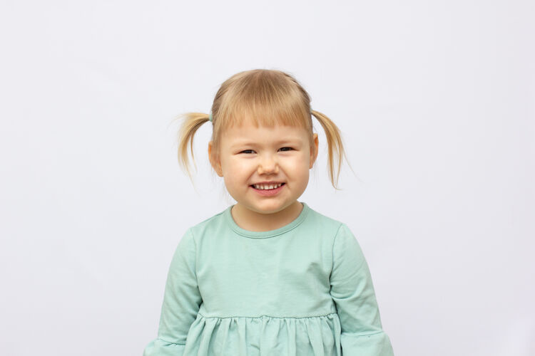 幼儿园在灰色背景上孤立的快乐的4岁女孩的肖像微笑人一个