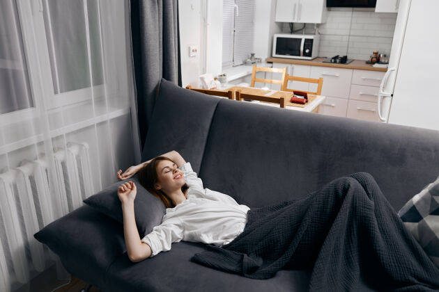 女性一个裹着毯子的女人躺在沙发上 望着窗外幸福女人新鲜