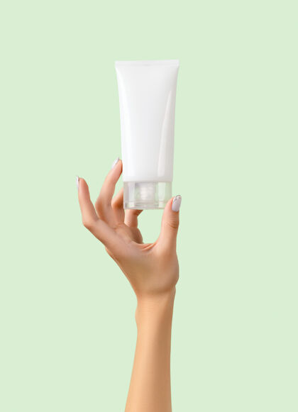 清洁剂女人的手拿着粉彩绿上的白色管护肤常规保湿剂产品