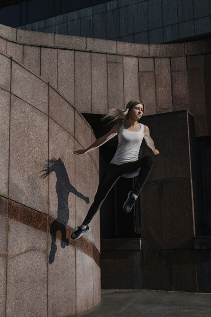 年轻年轻的运动女性在城市里做跑酷灵活女性活动
