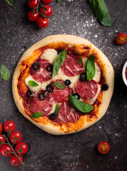 餐新鲜出炉的披萨 配橄榄 罗勒和配料 背景为黑色晚餐食物烘焙