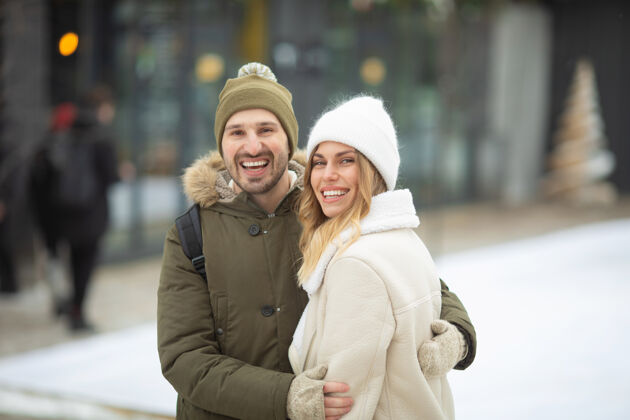 乐趣在冬季公园里 拥抱着微笑着看着相机的情侣白种人节日情感