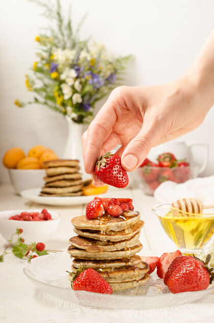 草莓女人做早餐 用草莓装饰一叠煎饼新鲜食物堆栈