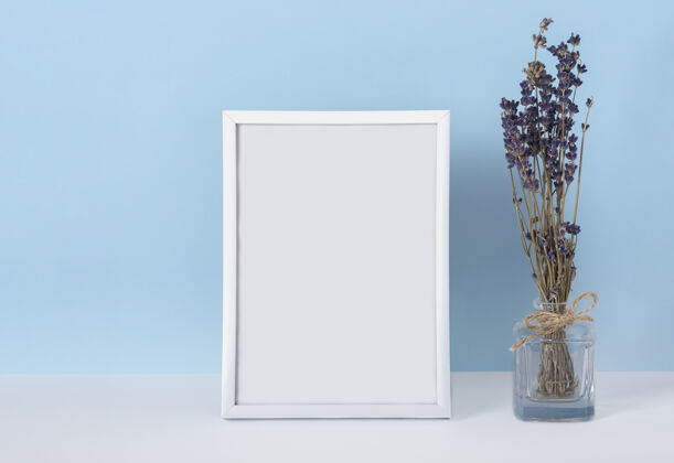 自然垂直emply春季白色相框模型 蓝色背景 花瓶中有薰衣草花妇女节概念空白女性装饰