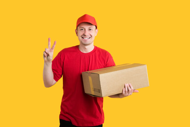 人穿着红色制服的快乐信使拿着一个盒子 在黄色上显示世界的标志男人制服黄色