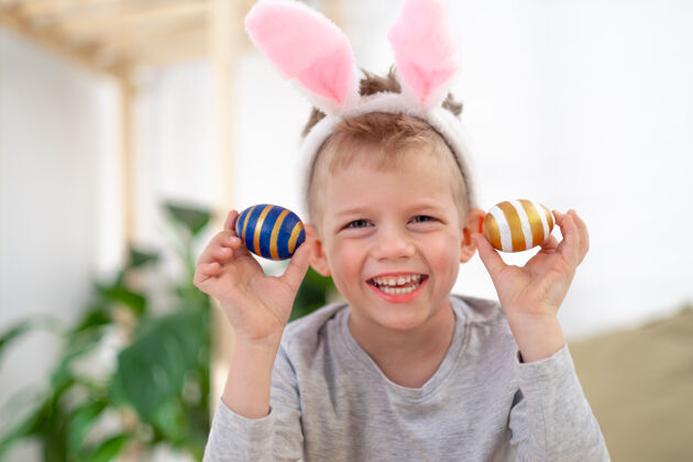 耳朵小男孩头上戴着兔子耳朵 家里有彩蛋童年绘画复活节