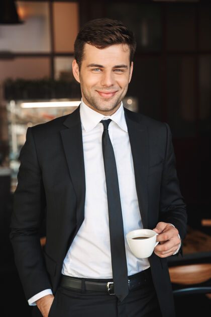 男人帅气的年轻商人穿着正装在咖啡馆里喝咖啡的照片环境领导工人