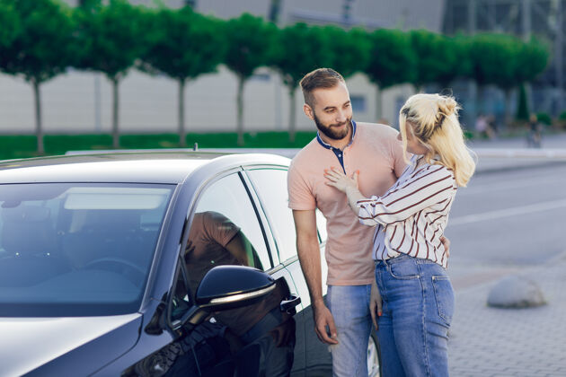 美丽幸福的年轻夫妇 男人和女人检查一辆新车汽车销售买一辆新车微笑运输持有