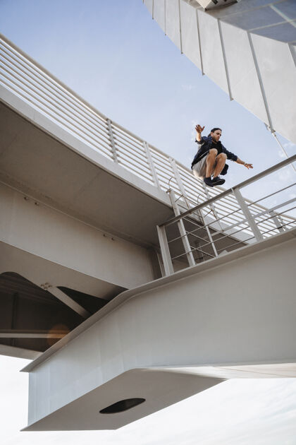 年轻从桥上跳下跑酷的人飞行障碍训练