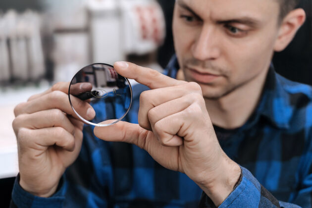 技师年轻的专业配镜师正在光学车间使用专用工具和设备进行配镜工作手制造商玻璃器皿