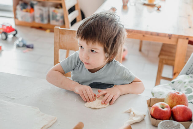 食物可爱的小男孩在厨房准备面团做糕点手小面粉