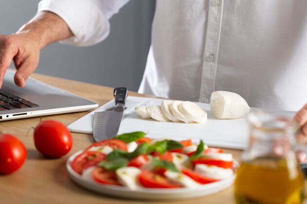 流行病家常菜concept.man公司在网上搜索如何烹调卡普里斯沙拉 是意大利著名的沙拉新鲜西红柿 马苏里拉奶酪和罗勒罗勒盘子厨房