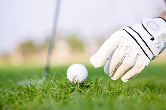 游戏在绿草高尔夫球场用球杆将高尔夫球放在球座上高尔夫球手俱乐部行动