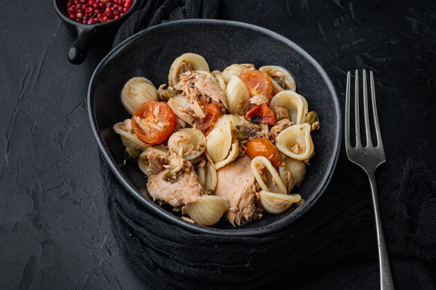 通心粉金枪鱼沙拉配意大利面和蔬菜在碗里 放在黑桌子上金枪鱼意大利菜可食用