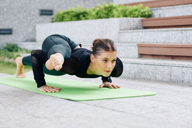 肌肉锻炼在瑜伽垫上做支架式运动时 坚定的柔韧性适合女人把腿放在胳膊上热身训练户外
