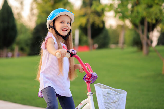交通快乐快乐的小女孩在公园里骑自行车运动微笑幼儿