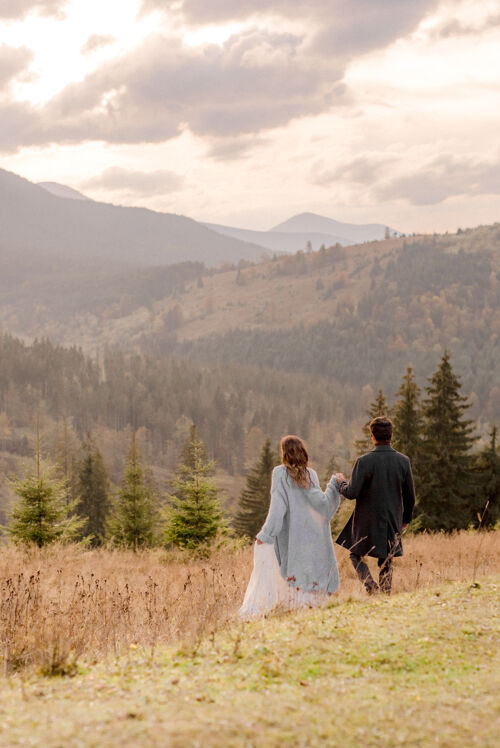 关怀新郎新娘在山里散步旅行夫妇旅行