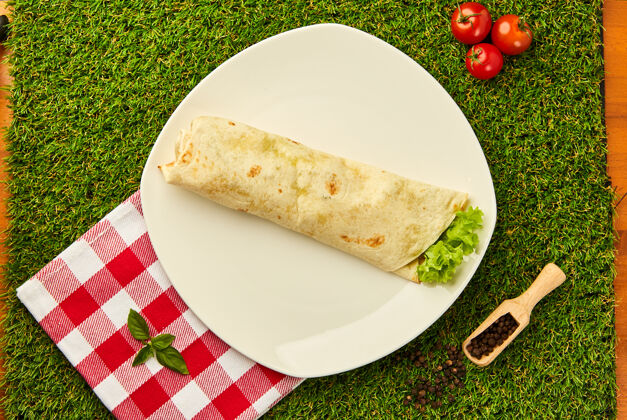 墨西哥玉米卷墨西哥玉米煎饼包上鸡肉和蔬菜 放在一盘绿草上 墨西哥沙瓦玛烤羊肉串法吉塔快餐