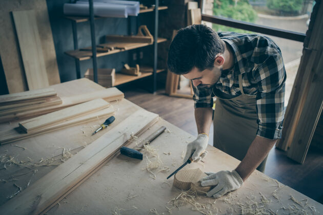 修理专心致志的人用凿子打磨木心 在手套上用建筑工具工作手工修复建筑