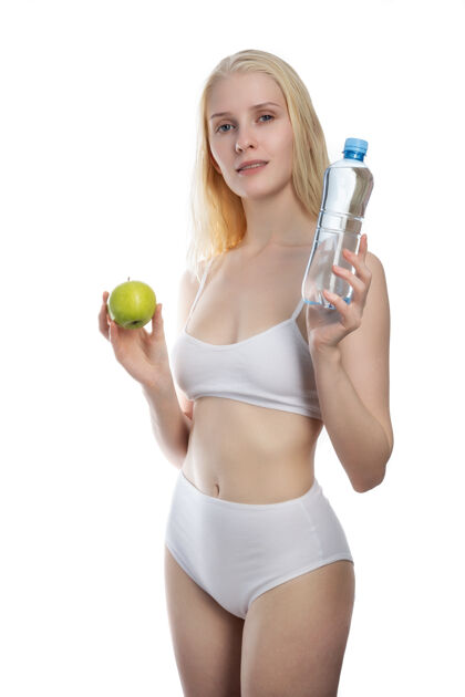 亚洲人健身女快乐微笑拿着苹果和水瓶子健康白色背景上隔离的白种人健身模特的生活方式照片瓶子女人持有