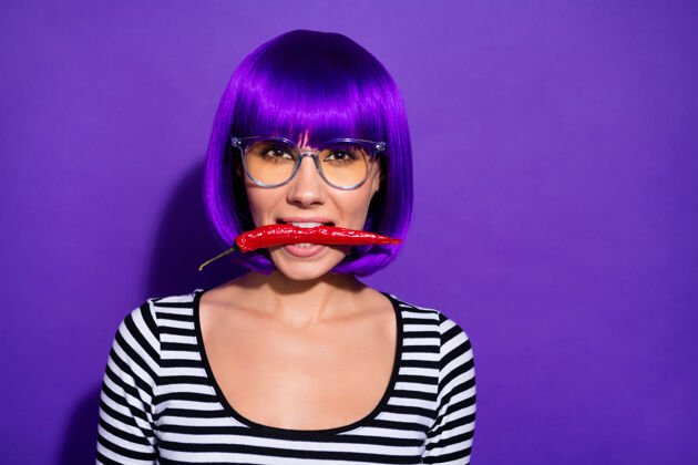 牙齿近距离的照片迷人的女士持有辣椒辣椒看起来穿着紫色假发条纹衬衫孤立ovr紫色背景生活方式女性头发