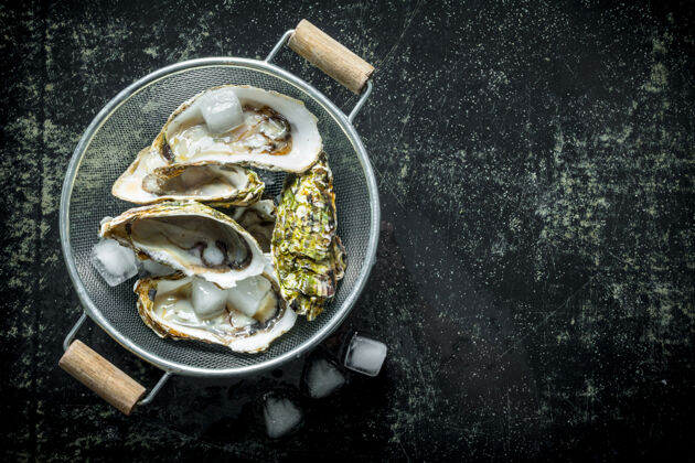 咸新鲜的牡蛎冰上黑乡村的桌子膳食贝类食物