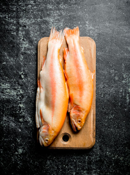 乡村新鲜的鳟鱼生在深色的木桌上自然红色营养