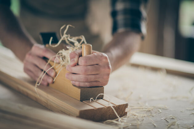 爱好他双手的特写镜头 勤劳的建设者 修理工 专家 企业家 做家居装饰 雕刻 木头 桌子上的开发项目细木工作物硬木