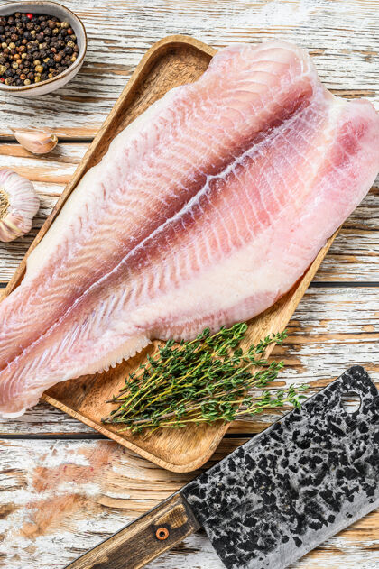 海鲜生白鱼片鲶鱼香料白色木制的背景.top查看鱼鳕鱼健康