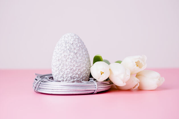 复活节银色的复活节彩蛋在巢里 白色的郁金香在粉红色上郁金香最小巢