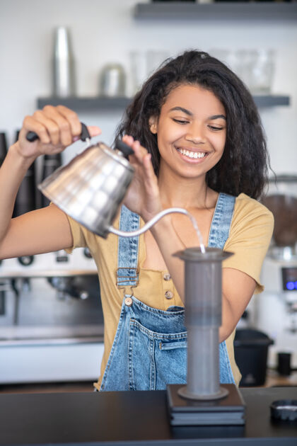 成功航空出版社 咖啡年轻一位黑发女子站在机场附近的咖啡店柜台后 手里拿着水壶工作日腰向上咖啡馆