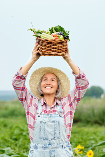 生物女人手里拿着一篮子丰收的有机蔬菜和根上的有机生物农场.秋天蔬菜收获乡村萝卜南瓜