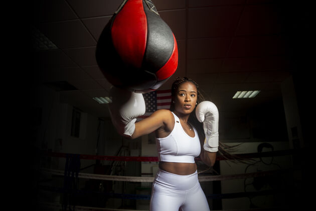 手年轻的美国黑人女子在体育馆里打着美国国旗训练拳击能量奥运会专业