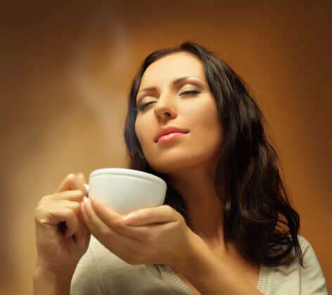 黑发喝咖啡或茶的美女成人茶饮用