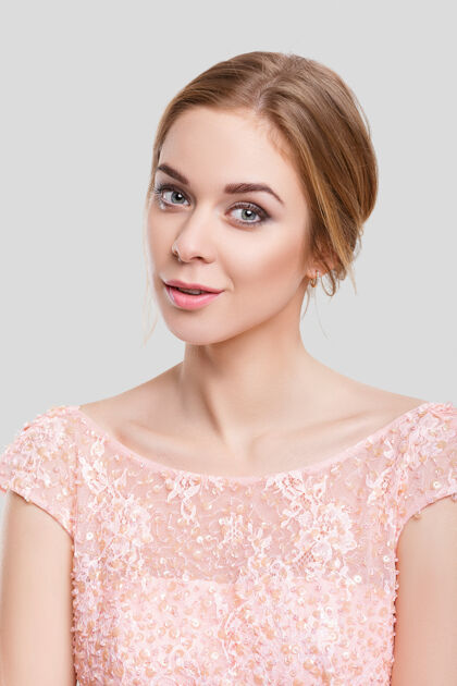 性感年轻漂亮的金发性感女人的肖像 在灰色背景上穿着粉色鸡尾酒裙时尚夏天头发