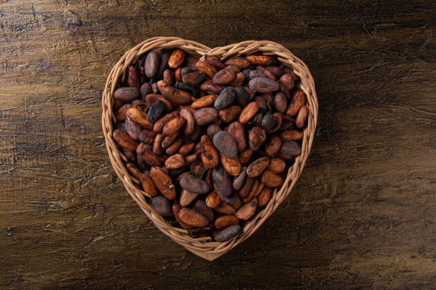 巧克力原汁原味的可可豆放在心形的篮子里 有着乡村的背景香气苦美食