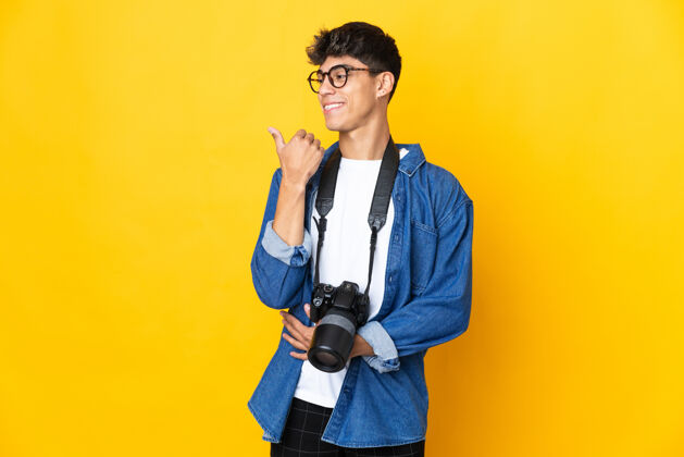 人年轻的摄影师越过隔离的黄色墙壁指着旁边的人介绍一个产品指向微笑点