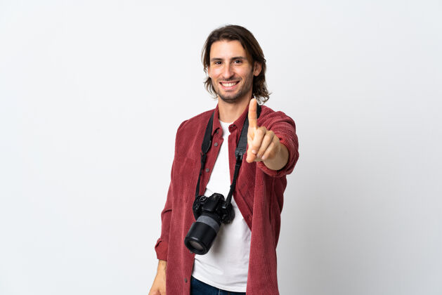 人被隔离在白墙上的年轻摄影师展示并举起一个手指设备人模型