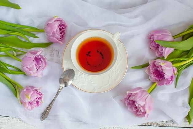 书静物茶杯和郁金香白色织物的花束健康桌子刷新