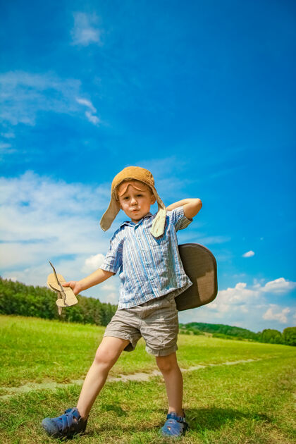 游戏飞机旁的一个男婴在空中玩弄大自然公园男孩度假飞行员旅行户外眼镜