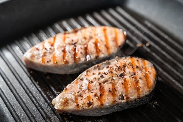 晚餐把烤三文鱼放在火红的烤架上牛排盘子热的
