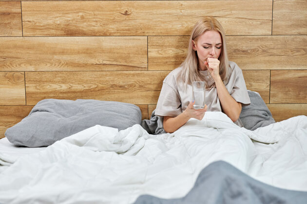 成人妇女有呼吸道症状发热 咳嗽 身体酸痛 独自坐在家里的床上 患上了严重的呼吸系统疾病疾病检疫自我隔离 健康护理理念症状床医疗