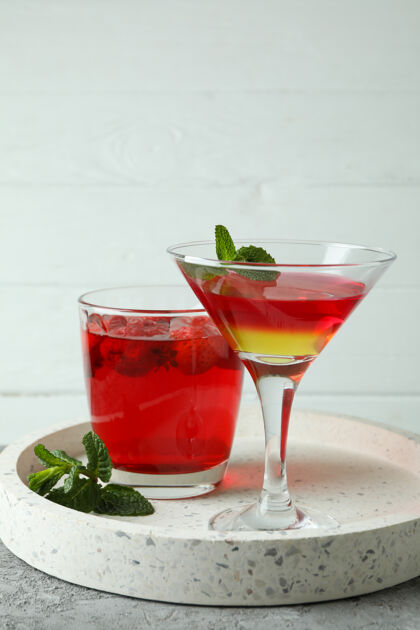 马提尼酒概念甜点与红色果冻在灰色纹理的表美食混合饮料