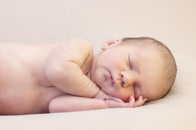 柔软新生婴儿睡觉和睡觉微笑接近美丽的熟睡婴儿的画像甜蜜睡着了休息