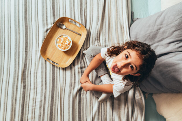 幼儿一个拿着早餐逗乐小女孩的顶视图房子快乐床
