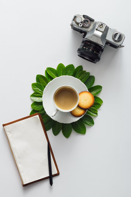 饮料创意平铺早晨咖啡花形笔记本和相机形状花园季节