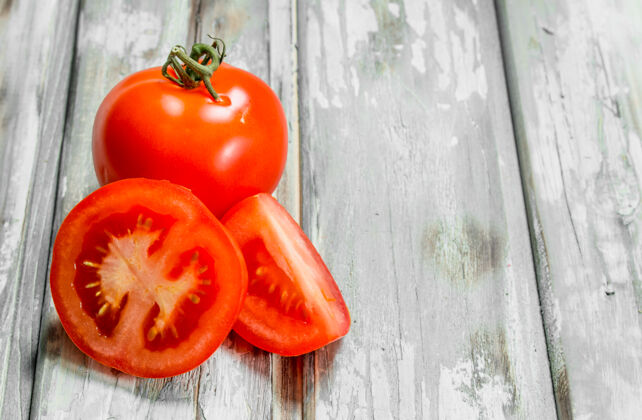 完美白木桌上放着几片熟番茄农业美味蔬菜