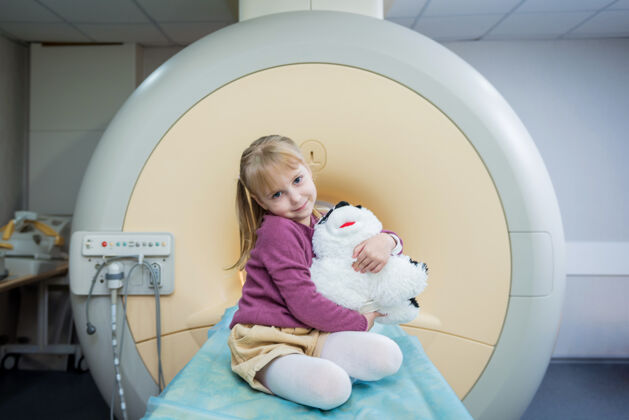 技师那个小女孩在核磁共振脑部检查前对着镜头摆姿势医学放射大脑